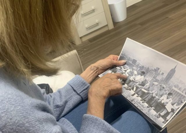Bingley Park resident looking through a historic black-and-white photograph during a reminiscence activity.